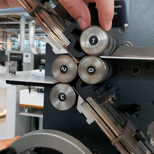 Ajuste micrométrico de rodillos en plegadora industrial para control de fibra en papel farmacéutico.